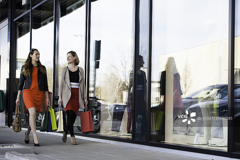 两位快乐的年轻女性在购物之旅中图片素材