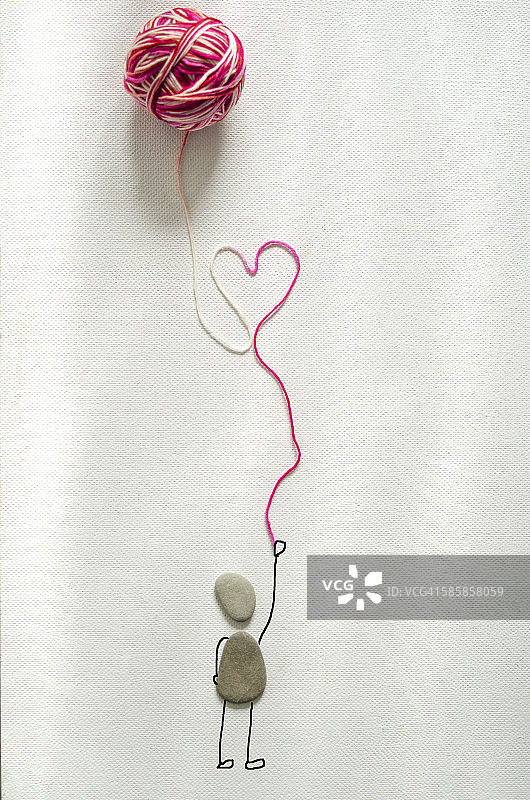 手捧羊毛心的石堆图片素材