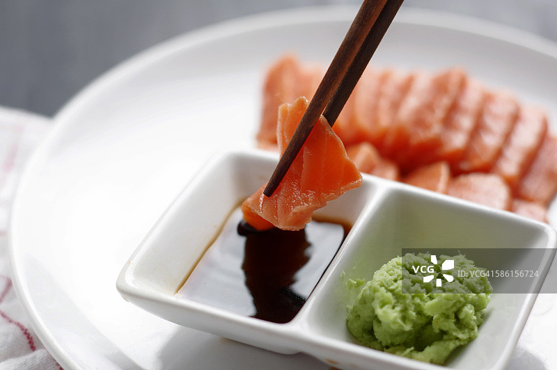 将切好的三文鱼肉浸入酱汁中图片素材