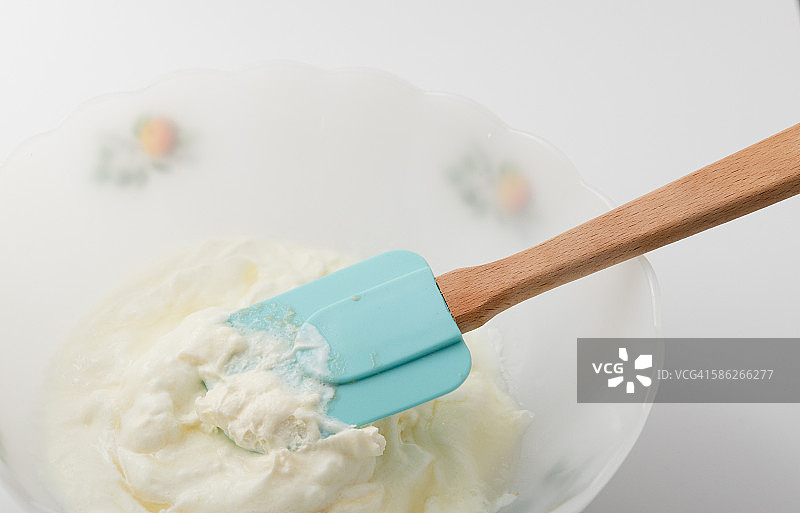 奶酪混合物中的蓝色刮铲图片素材