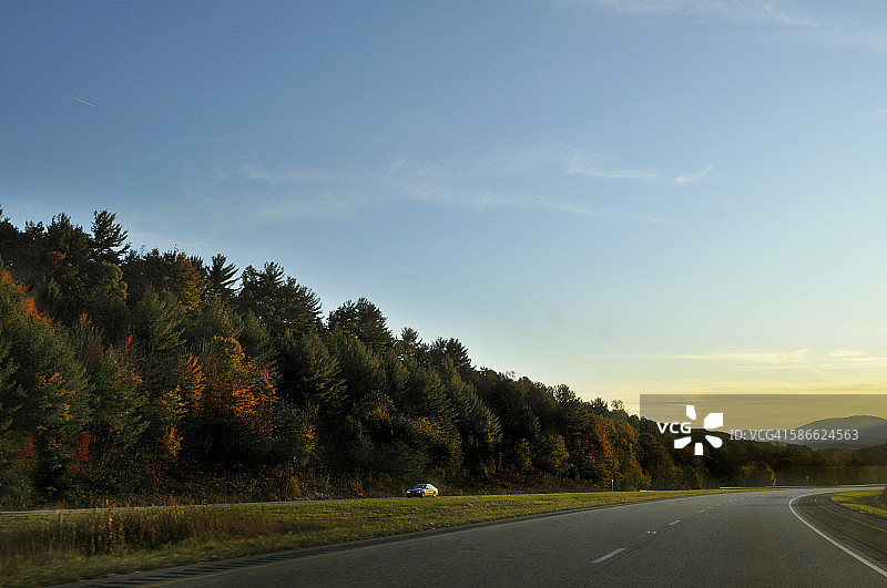 在高速公路上行驶的秋季落叶之旅图片素材