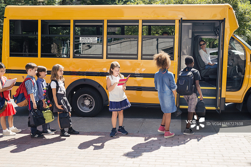 小学生们乘坐黄色校车图片素材