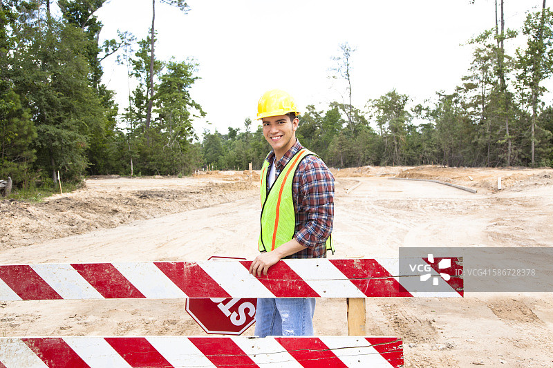 建筑工人手持停止标志在工地现场图片素材