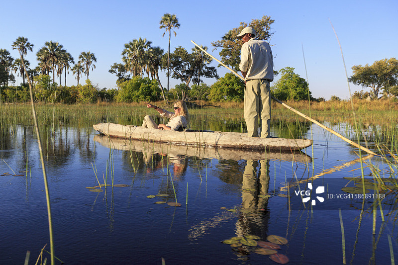乘坐mokoro船的女子和她的向导图片素材