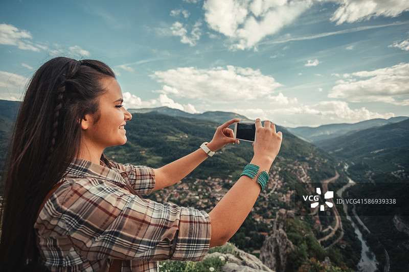 女孩在山顶上拍照图片素材