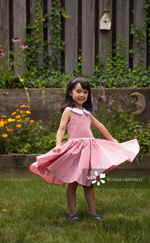 年轻亚洲女孩玩耍时转动裙子图片素材