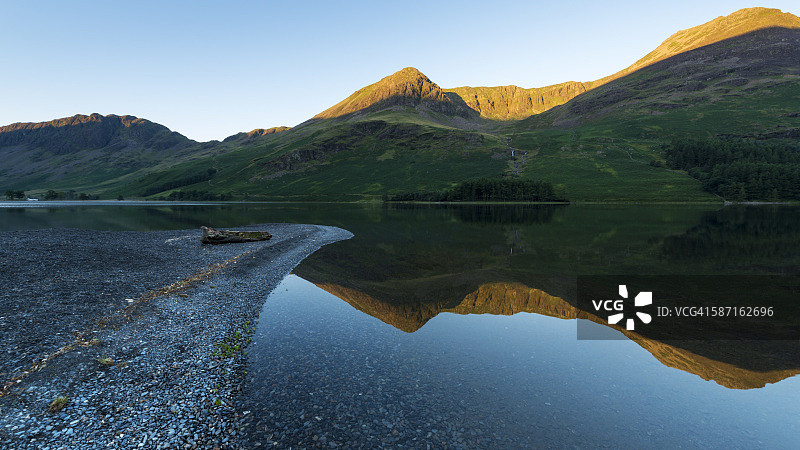 日出时分的巴特米尔湖，远处是High Stile、Red Pike和Haystacks山峰，沐浴在第一缕阳光中。英国湖区国家公园，欧洲。图片素材