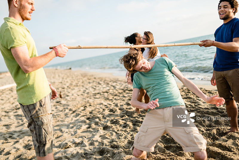 在海滩上玩 limbo 游戏的人群图片素材