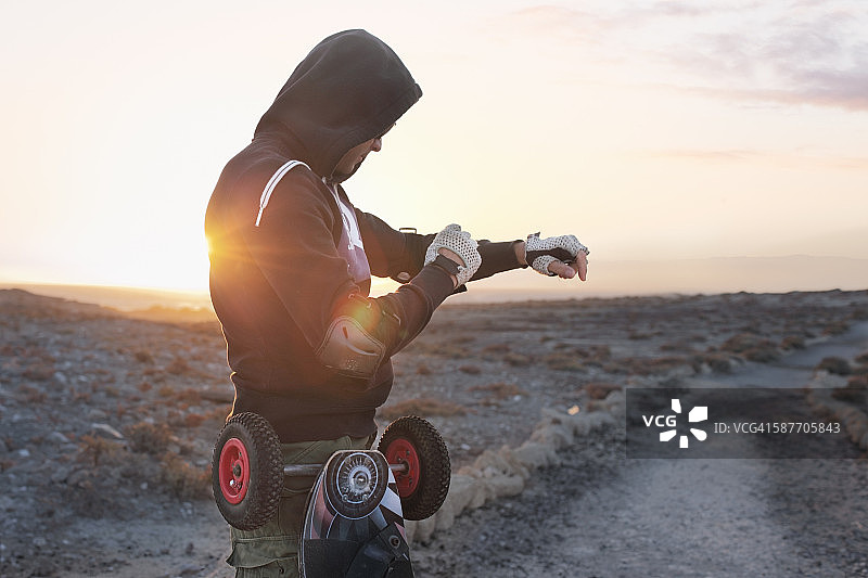 男人准备在日出时玩陆地滑板图片素材