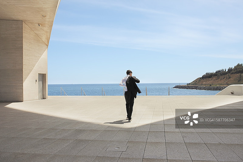 男子穿上西装，在海边散步图片素材