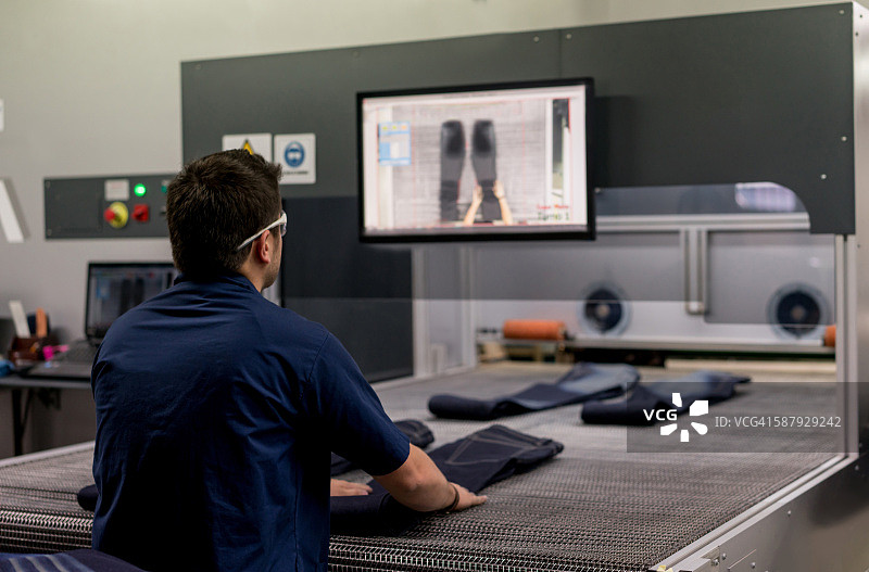 男人在服装厂操作激光机图片素材