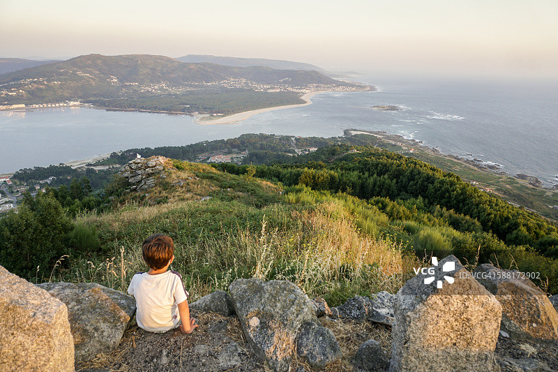 男孩从圣特克拉山看着米尼奥河的河口图片素材