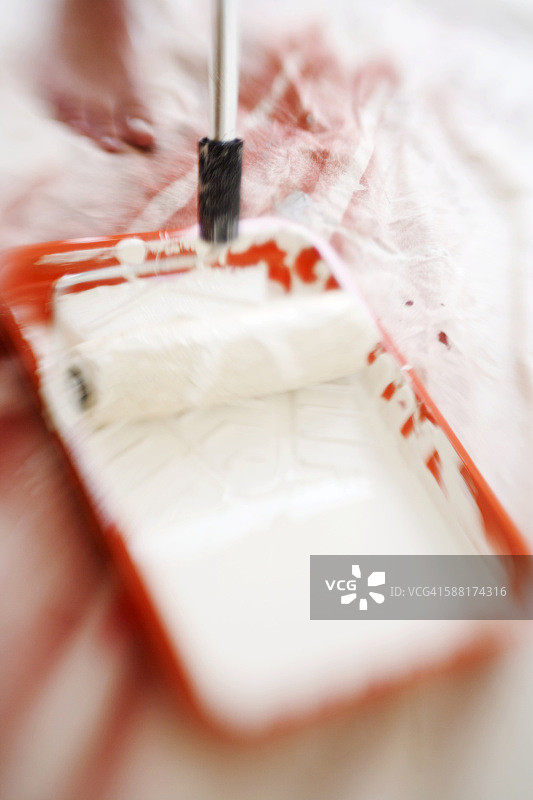 装有滚筒和白色油漆的橙色托盘图片素材