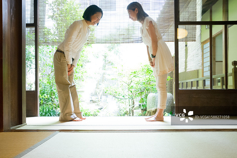 两名日本妇女在传统房屋中鞠躬图片素材