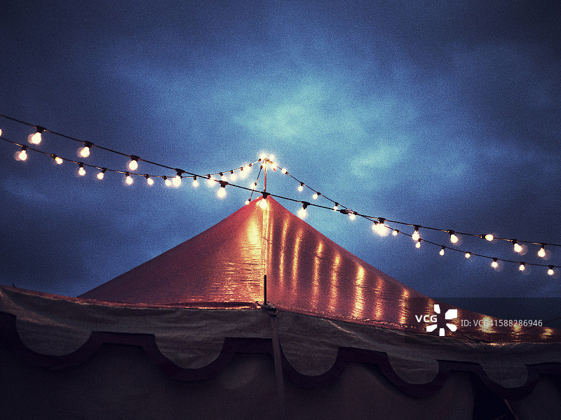 夜间马戏团帐篷和灯串低角度视图图片素材