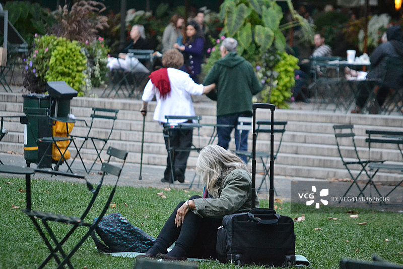 带着手提箱休息的老年妇女图片素材