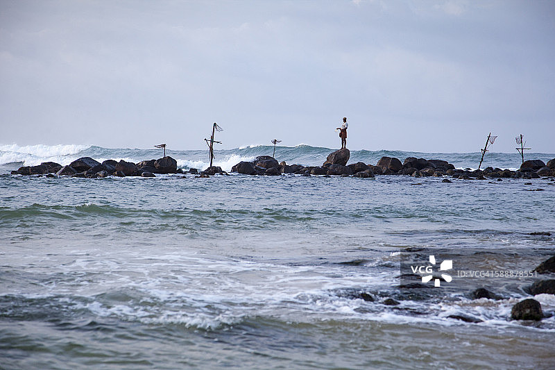 在米瑞萨海滩上钓鱼的高跷渔民图片素材