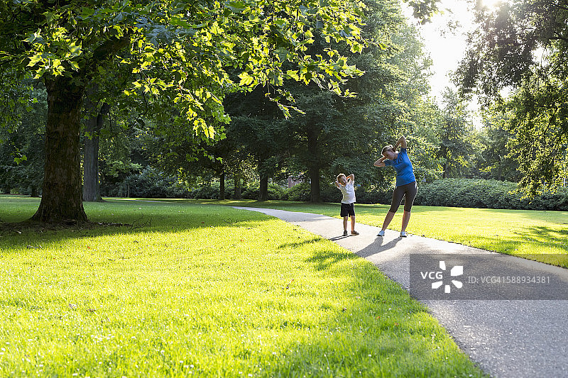 母亲和儿子(12-13岁)在公园里锻炼图片素材