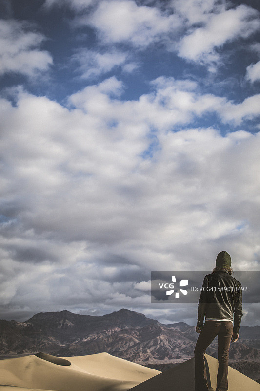 后视图：戴着绿帽子和黑色皮夹克的男人眺望死亡谷图片素材