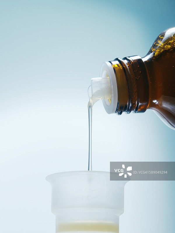 止咳糖浆倒入药杯图片素材