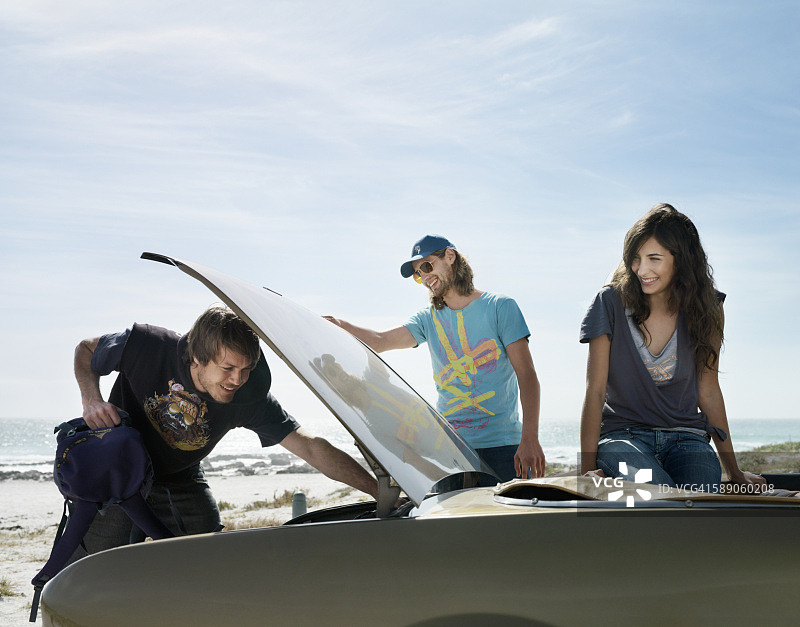 男人从敞篷车的后备箱里拿装备图片素材