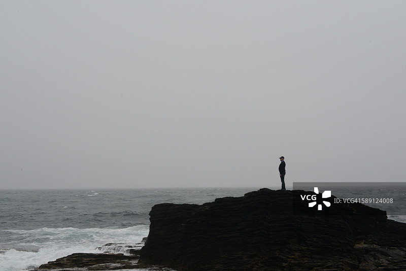 海边岩石上的男子图片素材