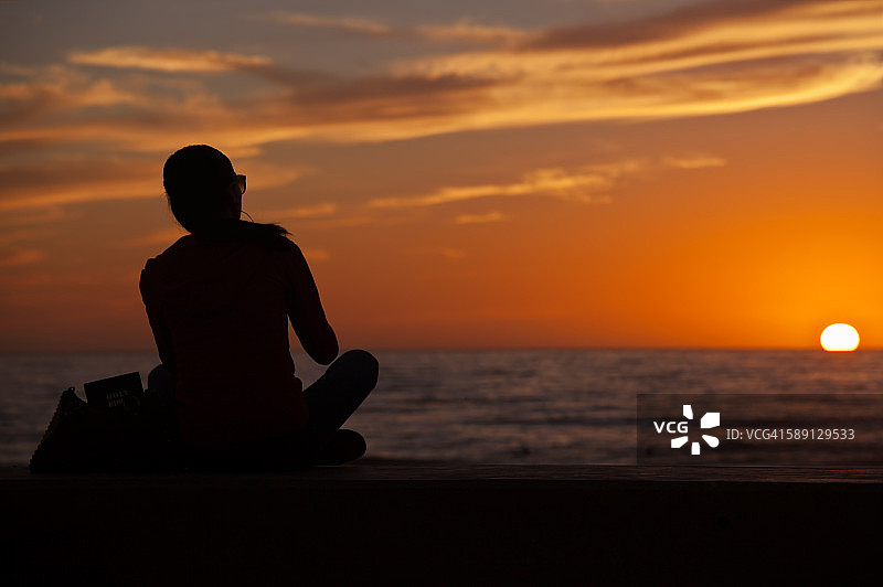 观看绚丽日落的剪影女人图片素材