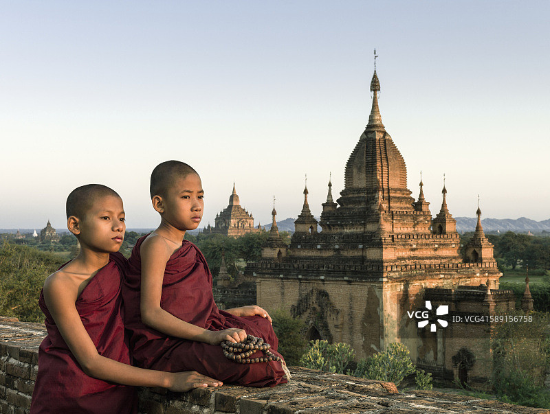 坐在寺庙顶上的年轻僧侣（13-15岁），缅甸曼德勒省图片素材