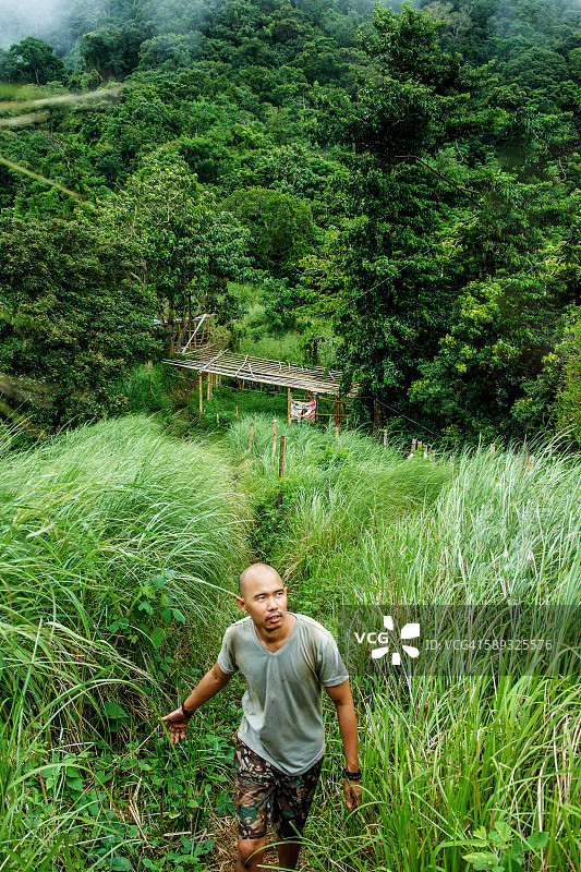 徒步旅行者在草山上行走图片素材