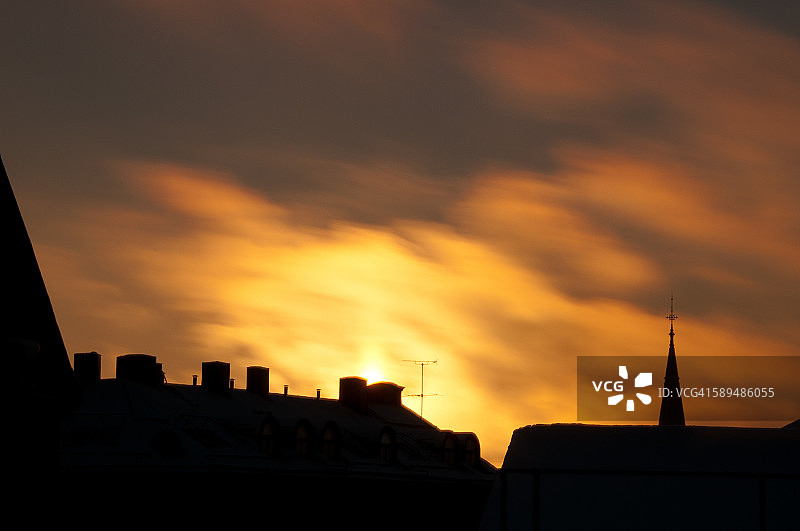在流动的云彩映衬下的城市天际线轮廓图片素材