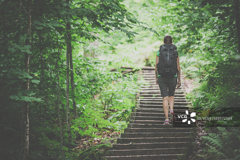 在森林小路上背包徒步的女人图片素材