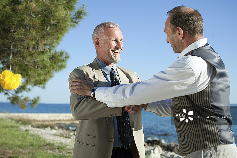 新娘的父亲与婚礼宾客握手图片素材