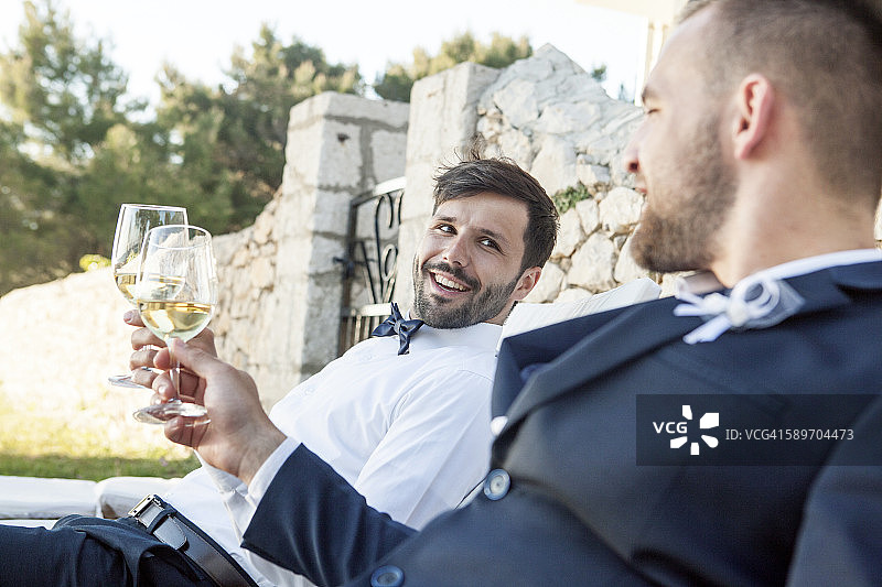 婚礼派对上新郎和朋友喝香槟图片素材