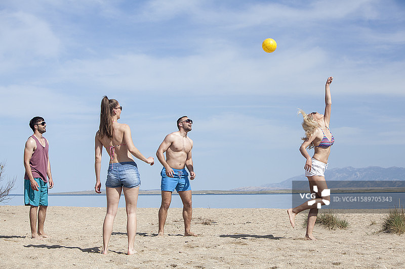 一群朋友在海滩上打沙滩排球图片素材