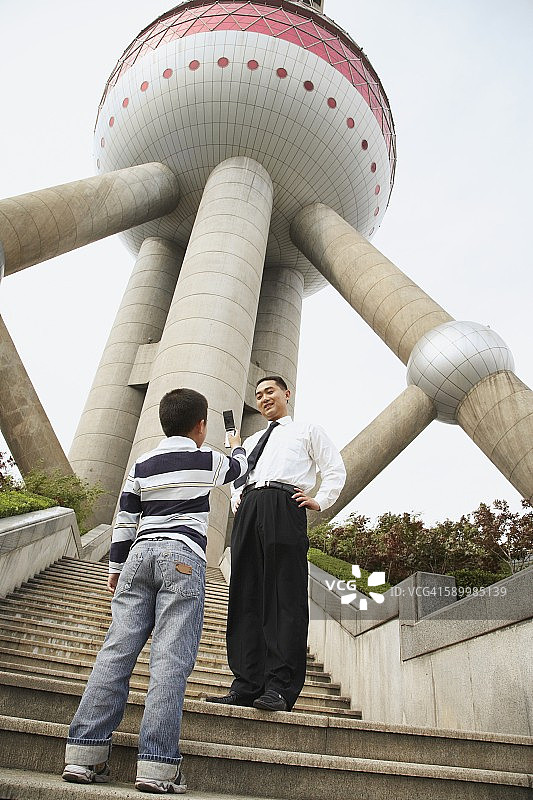 男孩用手机为父亲拍照图片素材
