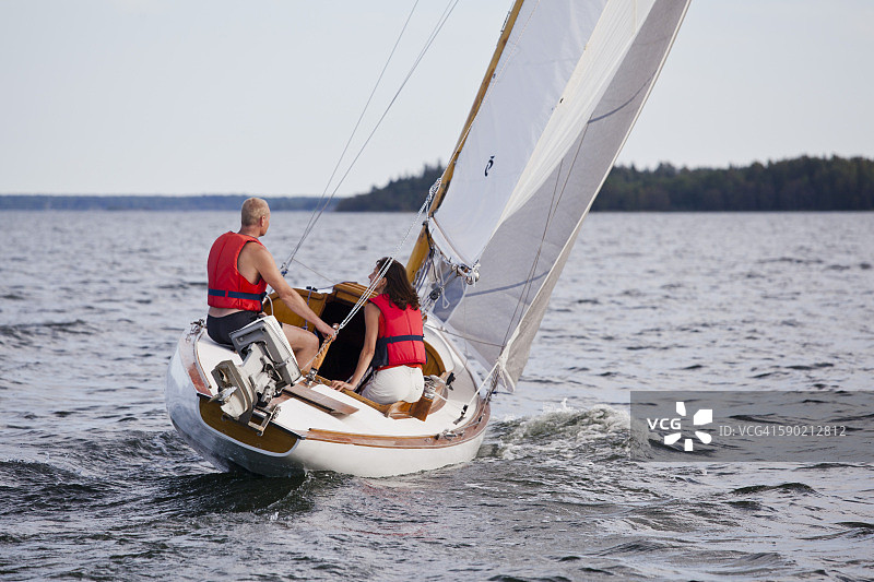 情侣在罗斯拉根的木制S30/M30帆船上航行图片素材