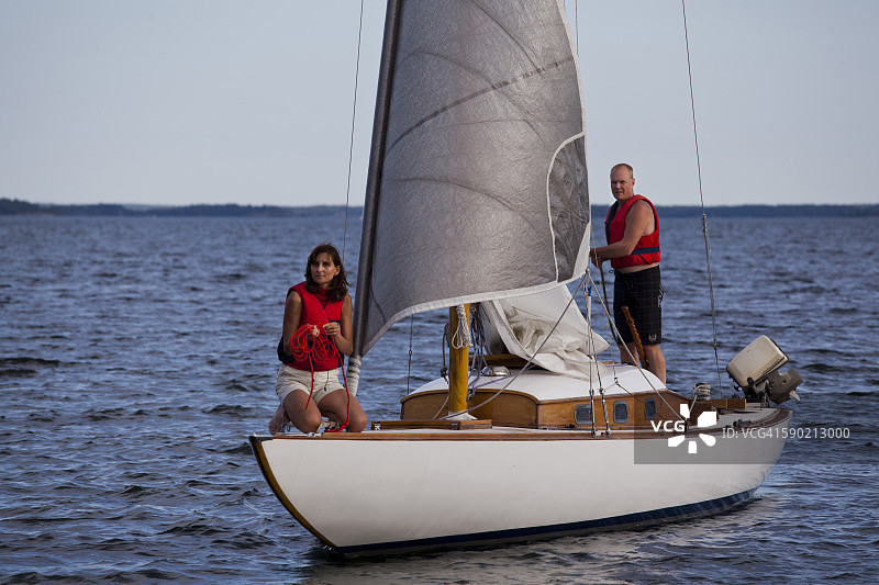情侣在罗斯拉根的木制S30/M30帆船上航行图片素材