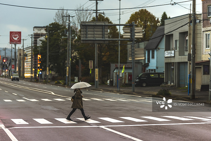 打伞过马路的女孩图片素材