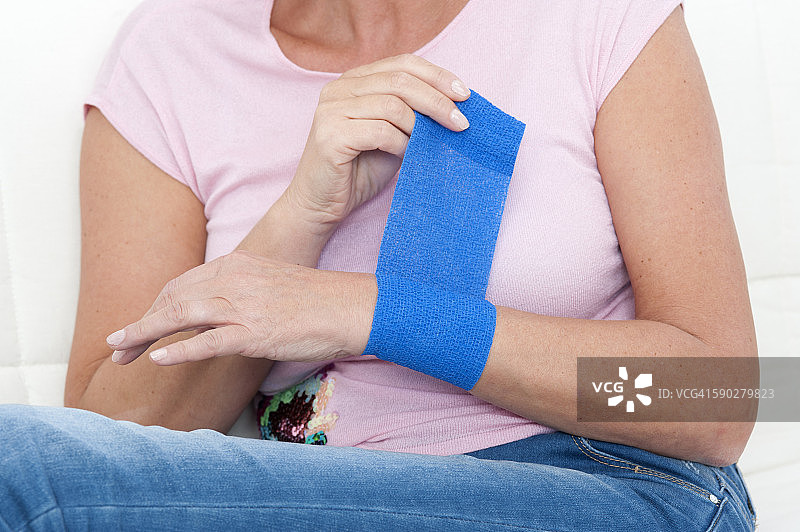 女人在手腕上贴绷带图片素材