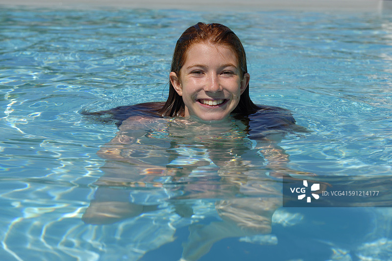 在游泳池里的微笑女孩肖像图片素材
