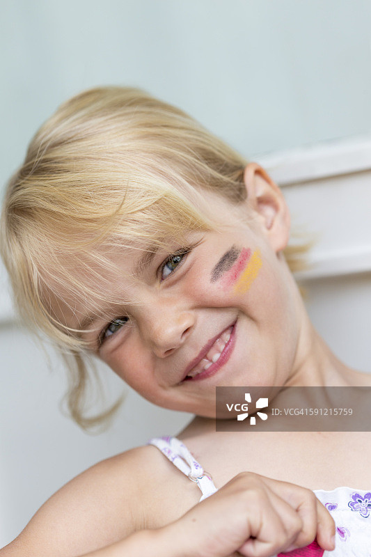 脸颊上画着德国国旗的金发小女孩肖像图片素材