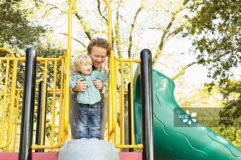 白人父亲和儿子在游乐设施上玩耍图片素材