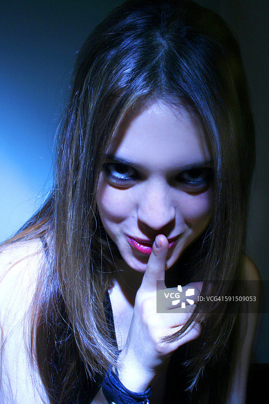 手指放在嘴唇上的女性肖像图片素材