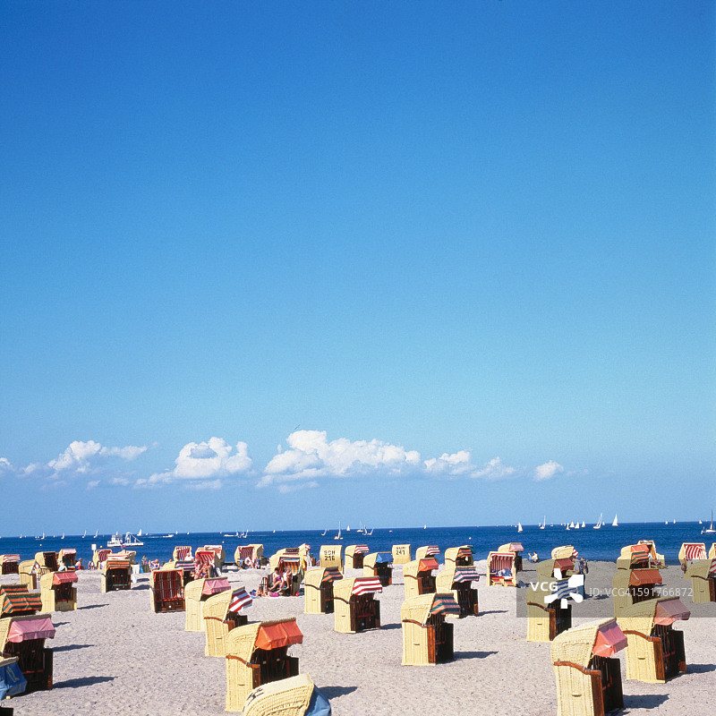 海滩上覆盖的椅子上方的蓝天图片素材