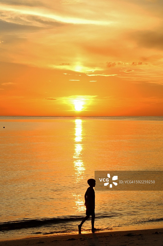 海滩上行走的儿童剪影，地点：美国佛罗里达州博尼塔斯普林斯赤脚海滩州立保护区图片素材