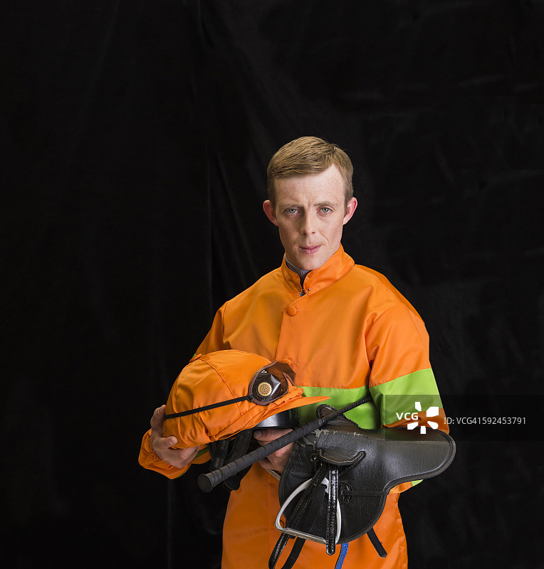 骑师手持马鞍和头盔图片素材