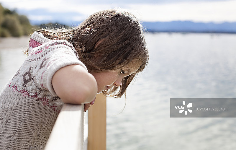 小女孩在栈桥上眺望湖泊图片素材