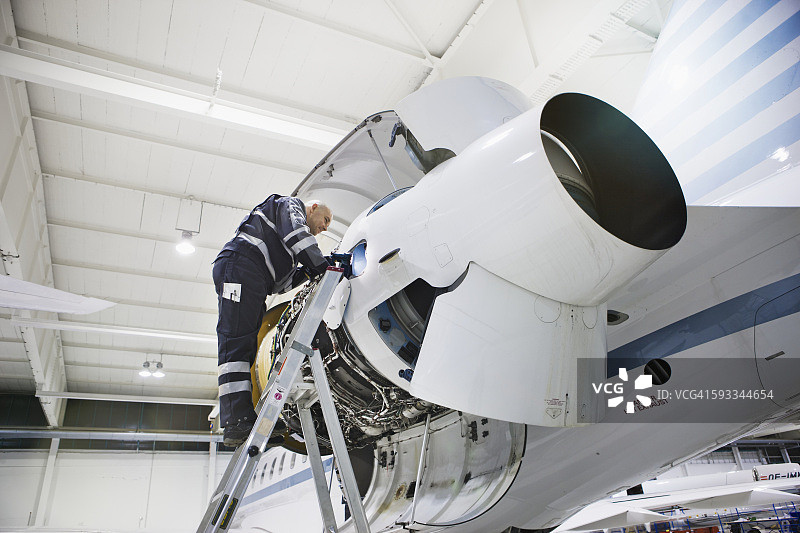 在工厂修理飞机引擎的修理工图片素材