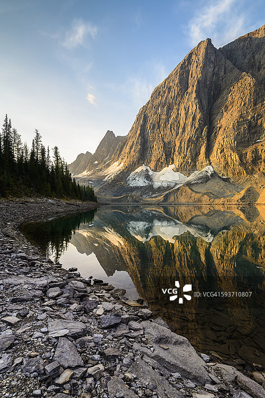 日出时分，岩壁倒映在冰湖中图片素材