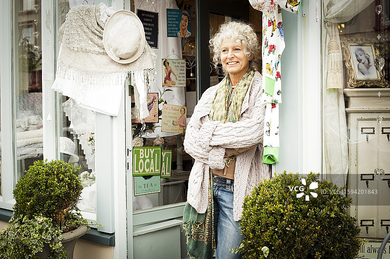 中年妇女站在商店门口图片素材